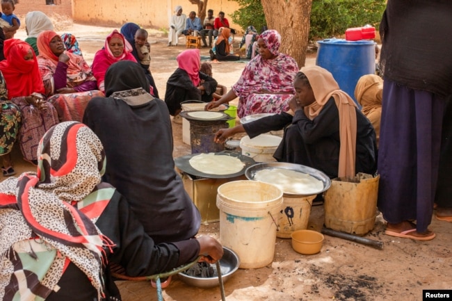 FILE - Sudanese women from community kitchens run by local volunteers prepare meals for people who are affected by conflict and extreme hunger and are out of reach of international aid efforts, in Omdurman, Sudan, May 13, 2024.