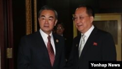 지난달 라오스 비엔티안에서 열린 북-중 양자회담에 앞서 중국 왕이 외교부장(왼쪽)이 북한 리용호 외무상과 악수하고 있다. (자료사진)