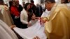 A Palestinian girl receives communion from the Latin Patriarch of Jerusalem Fouad Twal at the Church of St. Catherine, which is connected to the Church of Nativity, in the West Bank town of Bethlehem on Christmas day, Dec. 25, 2013. 