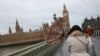 A woman holds her umbrella during a gust of wind on Westminster Bridge after Storm Darragh hit the country, in London on Dec. 7, 2024.