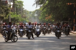 Hard-line Buddhists ride on motorbikes during a protest march, led by Rakhine State's dominant Arakan National Party, against the government's plan to give citizenship to some members of the persecuted Rohingya Muslim minority community in Sittwe, Rakhine State.