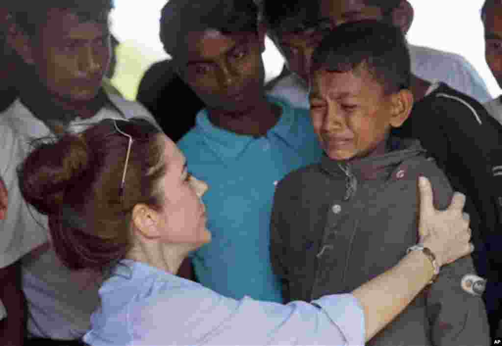 Denmark’s Crown Princess Mary, left, comforts Abdul Hafees, an internally displaced Muslim boy at Say Tha Mar Gyi camp in north of Sittwe, Rakhine State, Myanmar, Sunday, Jan. 12, 2014. Mary visited the camp and other relocation sites of the Buddhists, wh