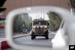 A patrolling U.S. armored vehicle is reflected in the mirror of a car in Kabul, Afghanistan, Aug. 23, 2017.