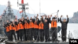 Tentara Korea Utara melambaikan tangannya menyambut kedatangan pemimpin mereka Kim Jong Un (tidak terlihat) mengunjungi Unit 158 Angkatan Laut Korea Utara (Foto: dok).