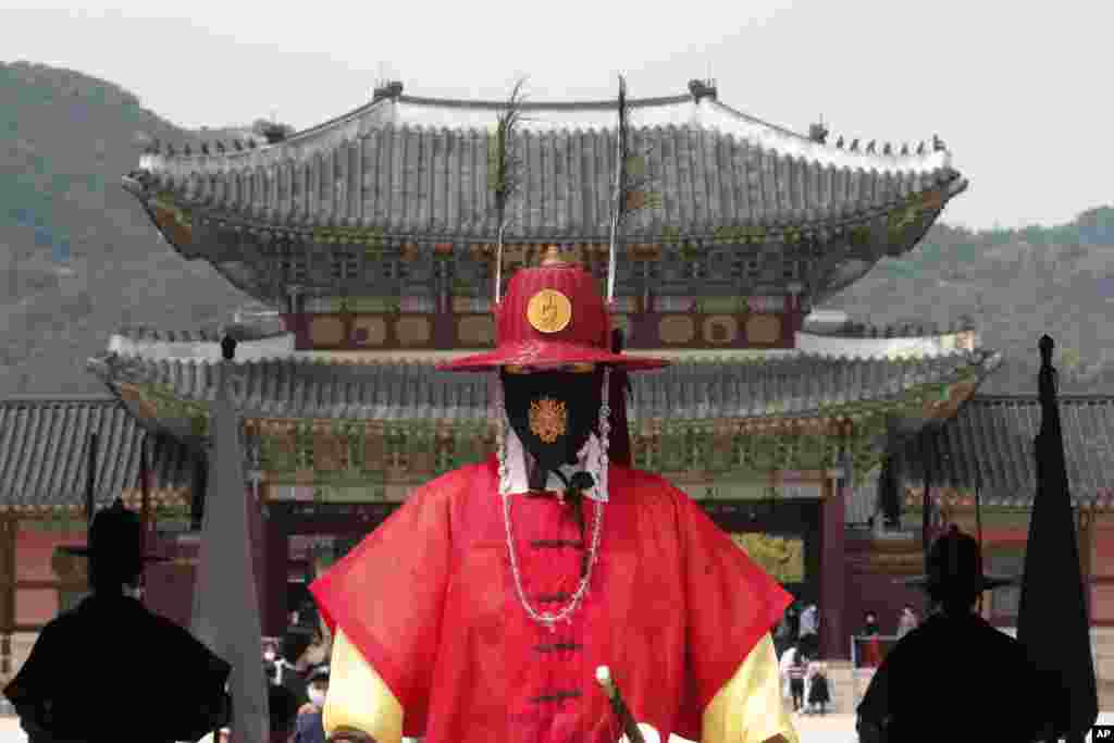 A South Korean Imperial guard wearing a face covering stands during a reenactment of the Royal Guards Changing Ceremony, at Gyeongbok Palace in Seoul.