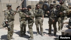 FILE - U.S. special forces soldiers consult before leaving their base in Helmand, Afghanistan Sept. 28, 2015. 
