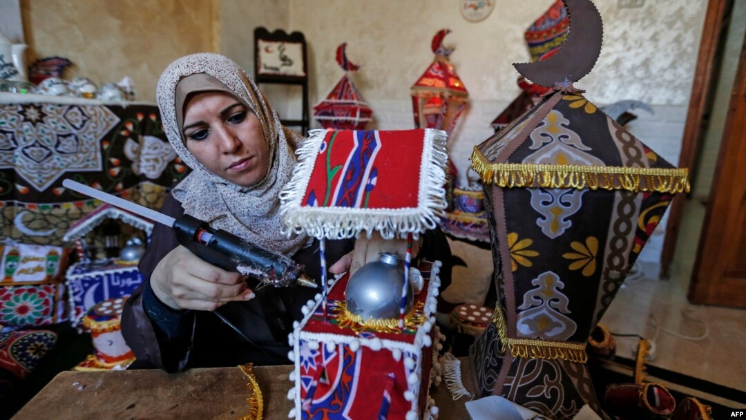 Hanan al-Madhoun (37) tengah membuat lentera tradisional "fanous" yang biasa digunakan sebagai dekorasi menyambut bulan suci Ramadan, di rumahnya di Gaza City, 1 April 2021, di tengah pandemi COVID-19. (MAHMUD HAMS / AFP)