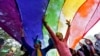 FILE - Participants dance under a a rainbow flag as they attend the sixth Delhi Queer Pride parade, an event promoting gay, lesbian, bisexual and transgender rights, in New Delhi, Nov. 24, 2013.