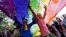FILE - Participants dance under a a rainbow flag as they attend the sixth Delhi Queer Pride parade, an event promoting gay, lesbian, bisexual and transgender rights, in New Delhi, November 24, 2013.