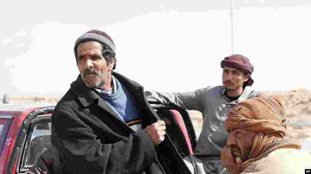 An Egyptian shepherd (left) tells of the charity offered by Libyans to help him flee the fighting, February 23, 2011. (VOA Photo/E. Arrott)