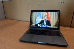 Chinese Foreign Minister Wang Yi is seen on a computer monitor at U.N. headquarters as he speaks during a virtual Security Council meeting during the 75th session of the U.N. General Assembly, Sept. 24, 2020.