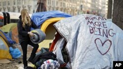 In compliance with new restrictions, an Occupy DC demonstrator packs up her camping gear at McPherson Square in Washington, January 30, 2012