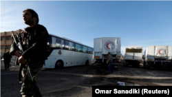 Families evacuated from Kabul, Afghanistan, walk through the terminal before boarding a bus after they arrived at Washington Dulles International Airport, in Chantilly, Va., on Friday, Aug. 27, 2021. (AP Photo/Jose Luis Magana)