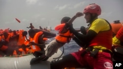 Des agents de l’ONG espagnole Proactiva Open Arms secourent des migrants en plein Méditerranée, à près de 15 miles au nord de Sabratha, Libye, 25 juillet 2017.