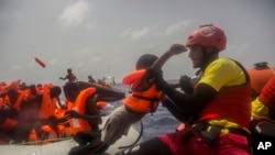 Des agents de l’ONG espagnole Proactiva Open Arms secourent des migrants en plein Méditerranée, à près de 15 miles au nord de Sabratha, Libye, 25 juillet 2017.