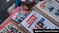 A street newspaper vendor arranges a stone at his stall where local newspapers´ covers show photos of Ethiopian Prime Minister Abiy Ahmed and leaders of the Tigray´s People Liberation Front (TPLF) in a downtown area of Addis Ababa, Ethiopia, Nov. 3, 2021.