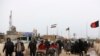 FILE - Afghans return to Afghanistan at the Islam Qala border with Iran, in the western Herat Province, Feb. 20, 2019.