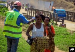 People crossing the border have their temperature taken to check for symptoms of Ebola, at the border crossing near Kasindi, eastern Congo, June 12, 2019, just across from the Ugandan town of Bwera.