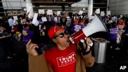 A supporter, foreground, of President Donald Trump yells as demonstrators chant outside Tom Bradley International Terminal during a protest, Jan. 30, 2017, at Los Angeles International Airport.