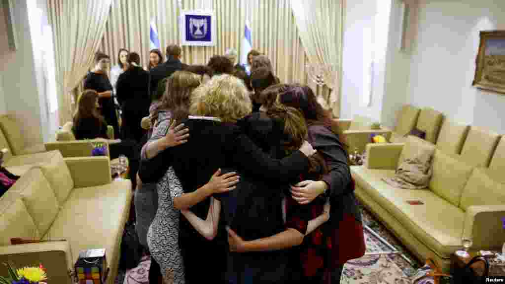 Para penyintas kekerasan seksual berpelukan dalam pertemuan dengan istri Presiden Israel di Yerusalem, setelah ambil bagian dalam sebuah proyek melawan kekerasan seksual (7/3). (Reuters/Ronen Zvulun)