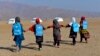 Afghan schoolgirls hold hands and walk towards their tent classrooms on the outskirts of Jalalabad, capital of Nangarhar province, Dec. 13, 2016. 