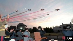 North Korean leader Kim Jong Un, 2nd right, watches a demonstration flight during the opening ceremony of the defense development exhibition "Self-Defence-2021" in Pyongyang, in this picture taken October 11, 2021, and released from North Korea's official