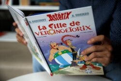 A journalist holds the new Asterix comic album named "La Fille De Vercingetorix" (Asterix and the Chieftain's Daughter) in Vanves near Paris, France, Oct. 22, 2019.