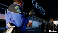 FILE - A County of Geneva police officer stands guard outside Cointrin airport in Geneva, Switzerland, Dec. 10, 2015. 