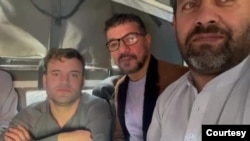 This screen grab from mobile phone video shot on Jan. 5, 2025, by Zalmay Atiq shows Enayatullah Omid, center, in the back of a police van with other Afghan nationals before being taken to a police station in Islamabad for document verification.