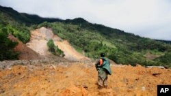 Un miembro rescatista busca sobrevivientes tras la destrucción causada por un deslizamiento de tierra masivo provocado por la lluvia en el pueblo de Queja, en Guatemala, el sábado 7 de noviembre de 2020, luego de la tormenta tropical ETA.