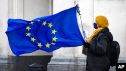 An anti-Brexit demonstrator holds an EU flag in Parliament Square, in London, Dec. 16, 2020.