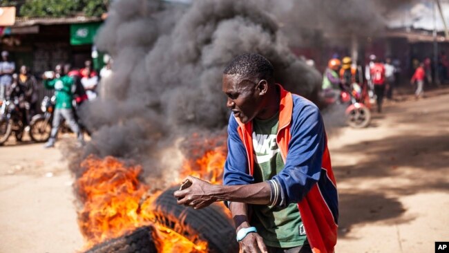 A protesters reacts next to a burning barricade during a mass rally called by the opposition leader Raila Odinga over the high cost of living in Kibera Slums, in Nairobi, March 27, 2023.