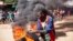 FILE: A protester next to a burning barricade during a mass rally called by the opposition leader Raila Odinga over the high cost of living in Kibera Slums, in Nairobi, Monday, March 27, 2023. Police are on high alert for protests authorities have termed illegal.