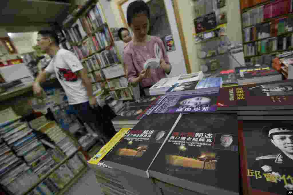 顾客在香港一家书店翻看与中国大陆有关的书籍。（2012年6月1日资料照）陈列的政治书里有邱会作回忆录和关于丁盛的书《落难英雄》。邱会作和丁盛是林彪部将，邱会作受林彪连累而被整肃，丁盛被调查， 但没受到牵连，不过在1977年被当局指控参与四人帮政变阴谋而落难。