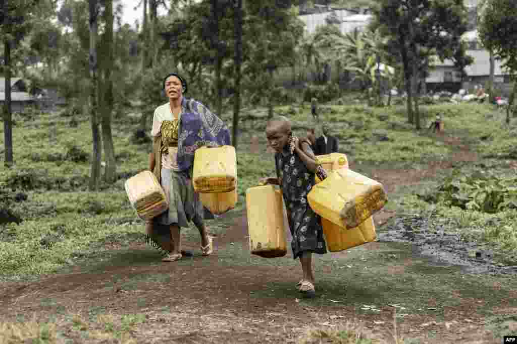 Residents carry jerrycans on their way to collect water from a water point installed by Doctors Without Borders (MSF) in Mugunga, Goma, Democratic Republic of Congo.