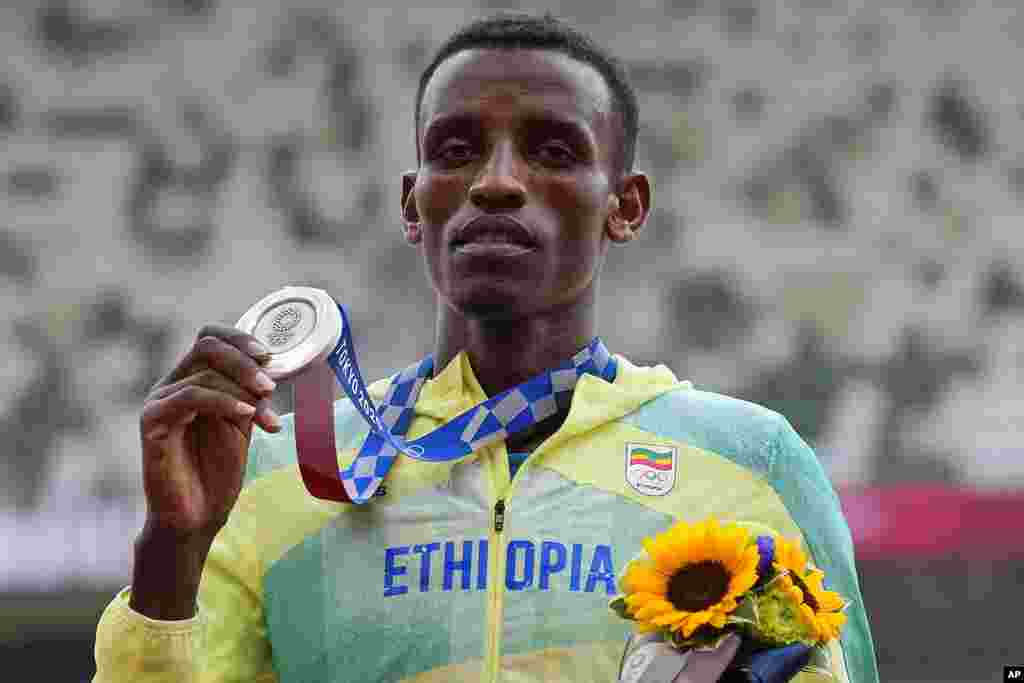 Lamecha Girma, of Ethiopia, holds his silver medal on the podium for the men's 3000-meters steeplechase at the 2020 Summer Olympics, Tuesday, Aug. 3, 2021, in Tokyo. (AP Photo/Francisco Seco)
