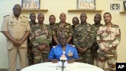 FILE—In this image taken from video provided by ORTN, Col. Maj. Amadou Abdramane, front center, makes a statement late Wednesday, July 26, 2023, in Niamey, Niger, as a delegation of military officers read out a series of communiques announcing their coup d'etat. 