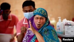 အိန္ဒိယမှာ ဒေသခံအမျိုးသမီးတဦးကို ကိုဗစ်ကာကွယ်ဆေး ထိုးနှံပေးနေတဲ့ ကျန်းမာရေးဝန်ထမ်း။ (ဒီဇင်ဘာ ၂၇၊ ၂၀၂၁)