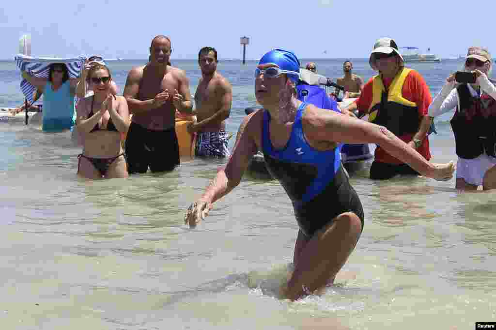 U.S. long-distance swimmer Diana Nyad , 64, walks to dry sand, completing her swim from Cuba as she arrives in Key West, Florida, Sept. 2, 2013. Nyad has become the first person to swim from Cuba without a shark cage.