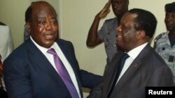 Charles Konan Banny (L), independent candidate for the 2015 presidential election, shakes hands with Independent Electoral Commission (CEI) President Youssouf Bakayoko (R) after registering his candidacy for the presidential election in Abidjan, Ivory Coast, Aug. 21, 2015.