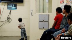 FILE - A detained immigrant child watches a cartoon with other young detained immigrants at a U.S Customs and Border patrol immigration detainee processing facility in Tucson, Arizona, June 28, 2018. 