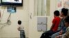 FILE - A detained immigrant child watches a cartoon with other young detained immigrants at a U.S Customs and Border patrol immigration detainee processing facility in Tucson, Arizona, June 28, 2018. 