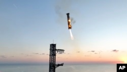 This image provided by SpaceX shows SpaceX's mega rocket booster returning to the launch pad to be captured during a test flight, Oct. 13, 2024, in Boca Chica, Texas. (SpaceX via AP)