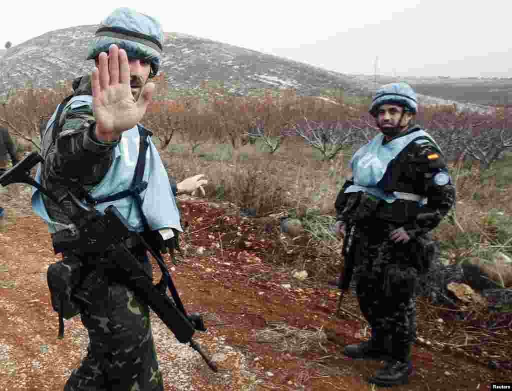 United Nations Interim Force in Lebanon (UNIFIL) troops react at the site of a shell that was launched from Lebanon to Israel, Sarada, Lebanon, Dec. 29, 2013.