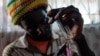 Un toxicomane chauffe un gramme de crystal meth dans le township de Glen View, à Harare, le 9 juin 2021.