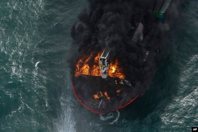طیارے سے لی جانے والی تصویر میں مال بردار بحری جہاز شعلوں کی لپیٹ میں ہے اور سیاہ دھوئیں کے بادل بلند ہو رہے ہیں۔ 26 مئی 2021