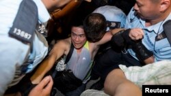 A protester is taken away by police officers after staying overnight at Hong Kong's financial Central district, July 2, 2014.