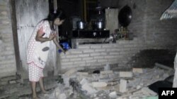 인도 술라웨이시의 토바닥 마을에서 규모 7.5의 지진으로 인해 부서진 벽돌 앞에 주민이 서 있다. 