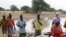 Villagers gather in front of a dam near the village of Labgar in northern Senegal on 12 Nov 2009. There is little to show for it apart from small acacia shrubs, but Senegal's leader believes in a Great Green Wall that will stem desertification across Afri
