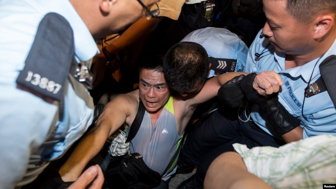Seorang pemrotes diciduk polisi setelah bermalam di distrik finansial utama Hong Kong (2/7). 